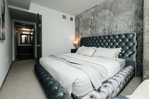 a bedroom with a large bed with a leather headboard at Hollywood Designer Apartment in Los Angeles