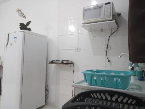 a small room with a refrigerator and a microwave at Loft10 COMPLETO AR CANAIS ASSINAT GARAGEM INTERNET prox Aparecida e Industrias in Pindamonhangaba