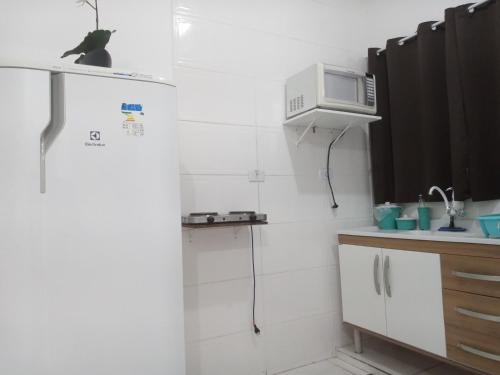 a kitchen with a refrigerator and a microwave at Loft10 COMPLETO AR CANAIS ASSINAT GARAGEM INTERNET prox Aparecida e Industrias in Pindamonhangaba