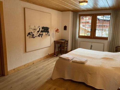 a bedroom with a bed and a picture on the wall at Villars SWISS Alpes in Villars-sur-Ollon