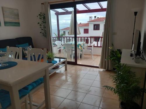 een woonkamer met een tafel en een balkon bij La rosa, vivienda vacacional in Breña Baja