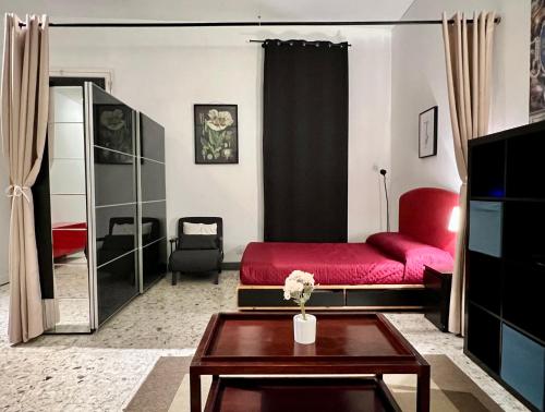 un soggiorno con letto rosso e tavolo di Spacious Studio in Via dei Coronari a Roma