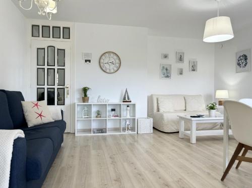 a white living room with a couch and a table at "LAS CAMELIAS SOMO" un lugar para desconectar!! Vistas al MAR!! in Somo