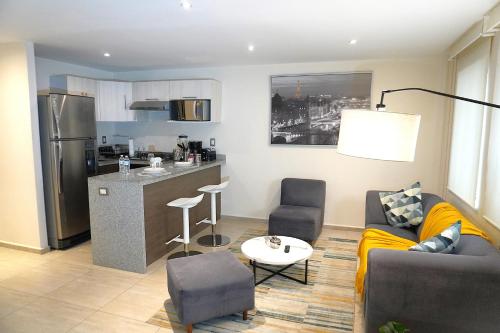 a living room with a couch and a kitchen at Magnífico departamento, muy bien ubicado. in Mexico City