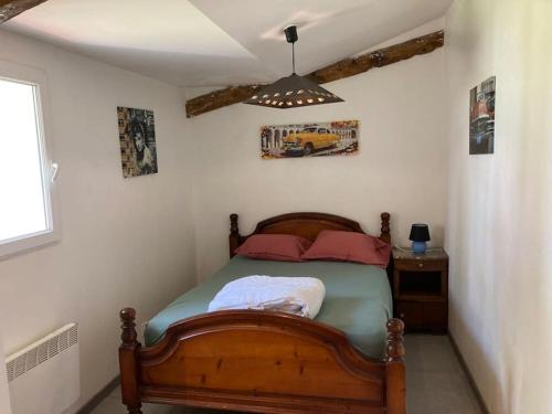 - une chambre avec un lit doté d'un cadre en bois dans l'établissement Maison proche de la mer!, au Perrier