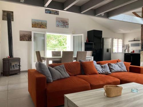 un salon avec un canapé orange et une table dans l'établissement Maison proche de la mer!, au Perrier