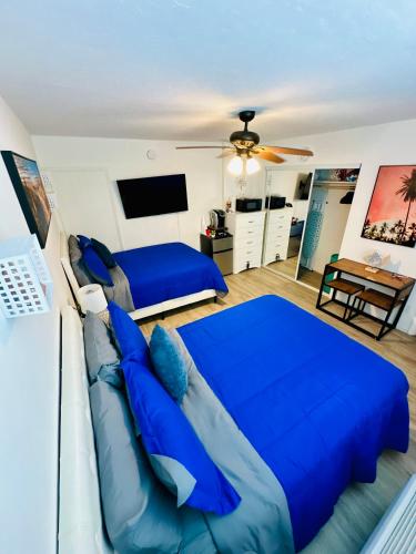 a bedroom with a blue bed and a couch at Superior beach studio with Pool Access and free parking in Daytona Beach