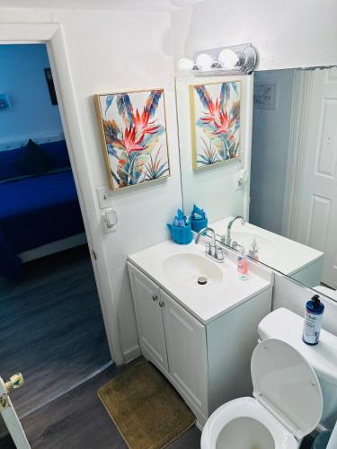 a bathroom with a toilet and a sink and a mirror at Superior beach studio with Pool Access and free parking in Daytona Beach