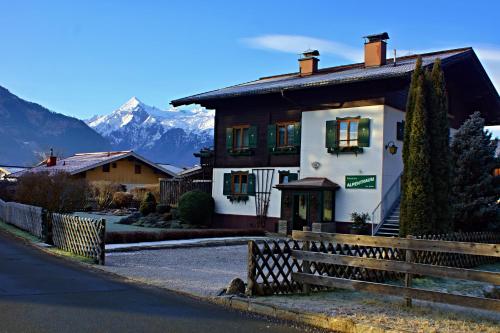 a house with a fence in front of a mountain at Pension Alpentraum in Zell am See