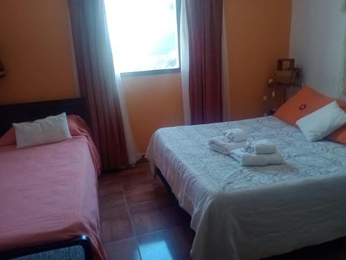 a bedroom with two beds with towels on them at Ipay Alojamiento Familiar in Purmamarca