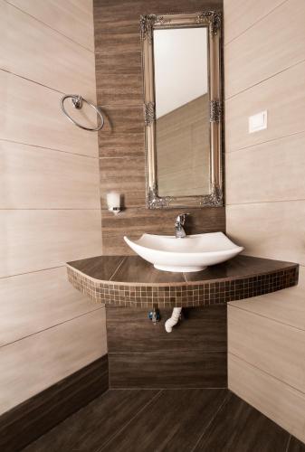 a bathroom with a sink and a mirror at Apartments Eleni 4 Seasons in Hanioti