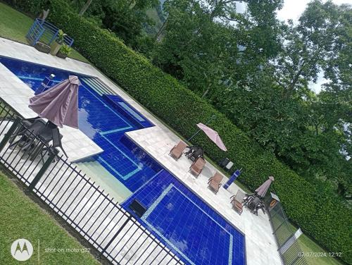 an overhead view of a swimming pool with chairs and an umbrella at HOTEl PALO GRANDE CF PEREIRA in Pereira