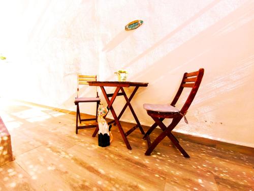 a dog sitting next to a table and two chairs at apartamento Chilches playa in Chilches