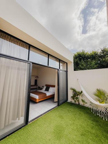 a house with a bedroom and a yard with grass at Casa Ocaso in Palomino
