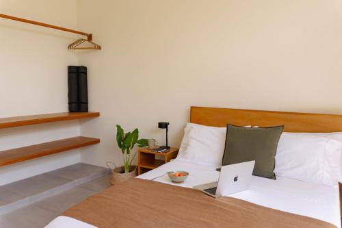 a bedroom with a bed with a laptop on it at Casa Ocaso in Palomino