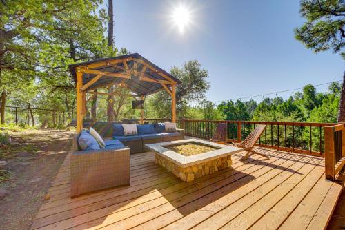 a patio with a couch and a fire pit on a deck at Hot Tub, Game Room Dog-Friendly Pine Cabin! in Pine