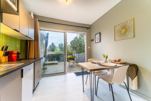 une cuisine et une salle à manger avec une table et des chaises dans l'établissement L Orea - Canon d Or - Terrasse - Wifi - Parking Gratuit, à Lambersart