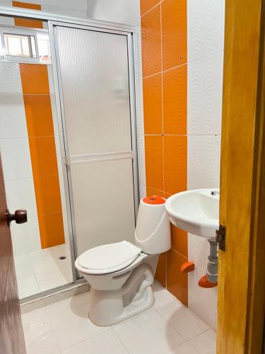 a bathroom with a toilet and a sink at Hostal Coco River Minca in Minca