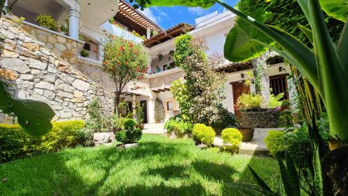 an exterior view of a house with a yard at Arte Sano Hotel San Cristobal in San Cristóbal de Las Casas