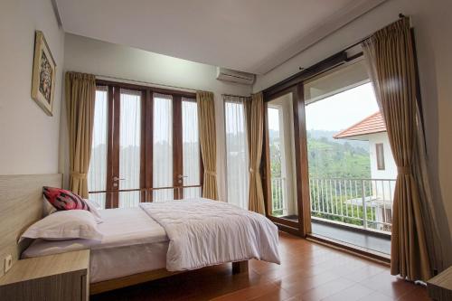 a bedroom with a bed and a large window at Villa Kencana Syariah in Bandung