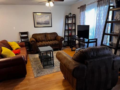 a living room with leather couches and a television at 7 minutes to IAD upstairs room in DC Metro area Middle size room in Sterling