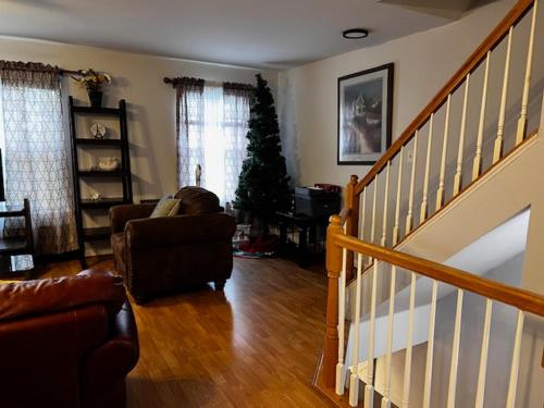 a living room with a staircase and a christmas tree at 7 minutes to IAD upstairs room in DC Metro area Middle size room in Sterling