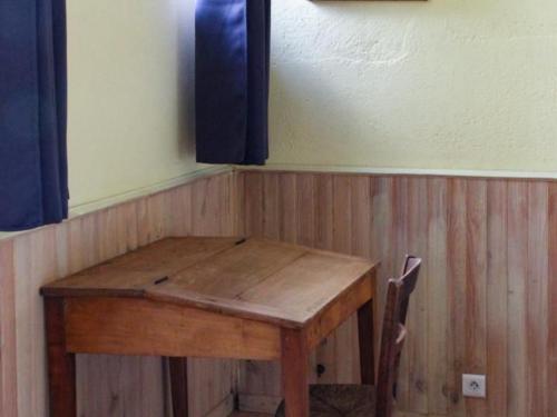 a wooden table with two chairs in a room at Maison rénovée avec piscine chauffée privative près de Challans et Aizenay - FR-1-426-258 in Saint-Christophe-du-Ligneron