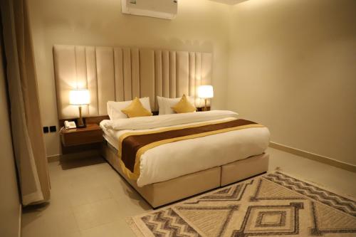 a bedroom with a large bed with two lamps at افال للشقق المخدومة -المونسية in Riyadh