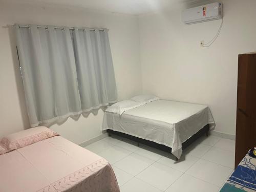 Giường trong phòng chung tại Oásis do Prado, casa de temporada