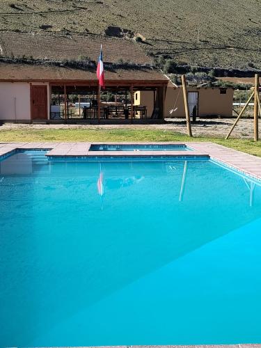 a large blue swimming pool in front of a building at Cabaña en Parcela, Valle del Elqui in Diaguita