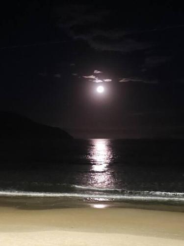 a moonrise over the ocean at the beach at night at Nosso Mar in Florianópolis