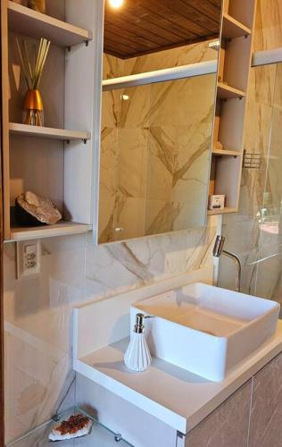 a bathroom with a sink and a mirror at Nosso Mar in Florianópolis