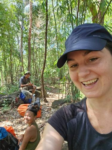 a woman in a hat is smiling in the woods at Banlung Mountain View Treks & Tours in Banlung