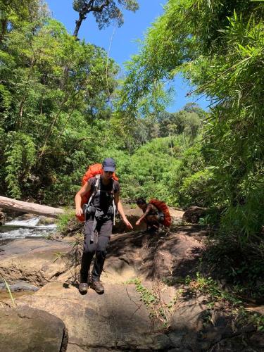 two people walking on a trail in the jungle at Banlung Mountain View Treks & Tours in Banlung