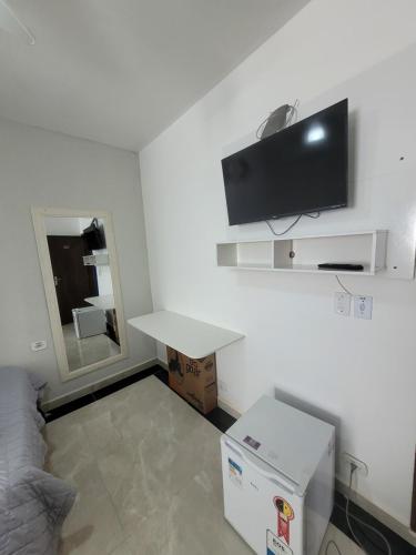 a small room with a table and a tv on the wall at Hospedaria São Benedito in Guararema