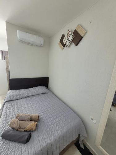a small bedroom with a bed with a gray bedspread at Hospedaria São Benedito in Guararema