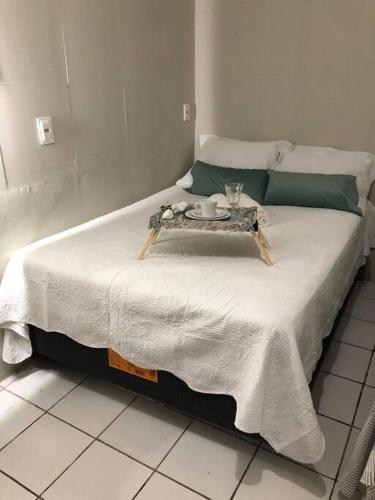 a bed with a table on it in a room at Casa na Praia de Iracema R&S in Fortaleza