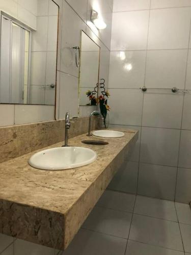 a bathroom with two sinks and a mirror and a shower at Casa na Praia de Iracema R&S in Fortaleza