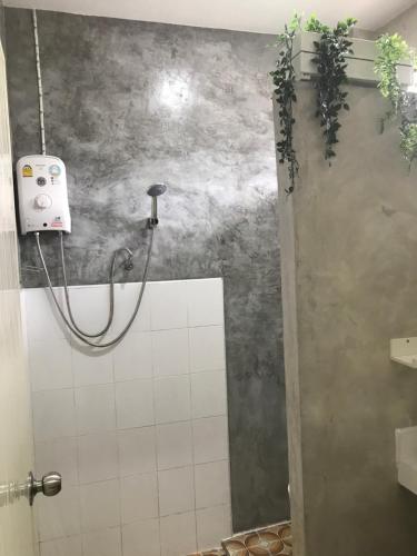 a bathroom with a shower with a hose on the wall at New Moon in Thongsala