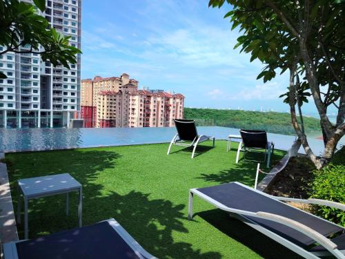 a lawn with chairs and a pool in a city at View of the whole Georgetown in George Town