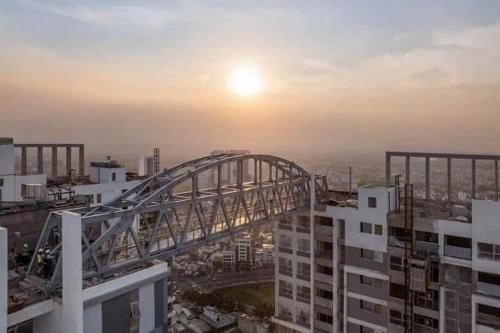 a bridge in a city with the sunset in the background at Happy One Central in Ga Phú Văn