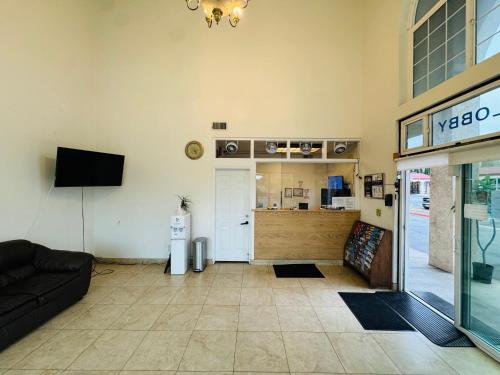 a living room with a couch and a tv at Casa Blanca Hotel - Azusa, Los Angeles in Azusa