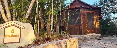 a small building with a sign in front of it at Eco Aldea kinich Ahau in Xpujil