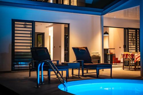 a room with two chairs and a swimming pool at night at Secret Pearls by Matira Beach in Bora Bora