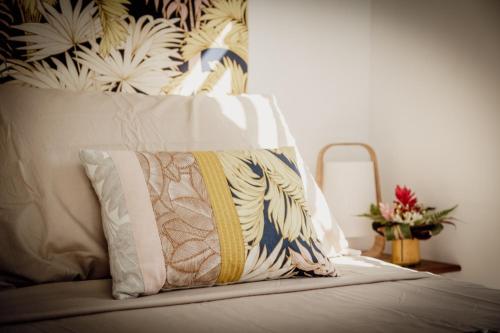 a pillow sitting on top of a bed at Secret Pearls by Matira Beach in Bora Bora