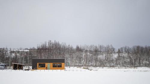 a small cabin in the snow in a field at Farm Stay Ezura Farm in Engaru