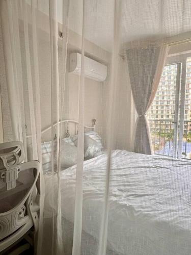 a bedroom with a canopy bed with a window at Claire's Empire in Lapu Lapu City