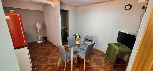 ein Wohnzimmer mit Tisch und Fernseher in der Unterkunft Casa interior cercana aeropuerto in Santiago