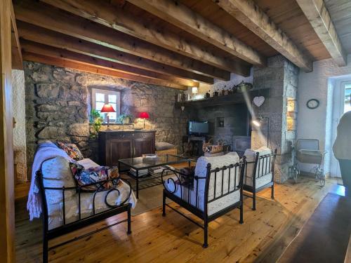 - un salon avec trois chaises et un mur en pierre dans l'établissement Gîte Nature au Chambon-sur-Lignon: Terrasse, Wifi, Proche Activités et Commerces - FR-1-582-137, au Chambon-sur-Lignon