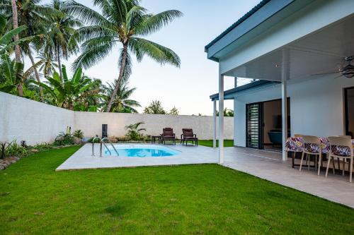 a backyard with a swimming pool and a house at Secret Pearls by Matira Beach in Bora Bora